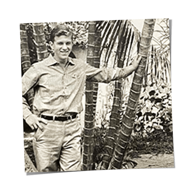 Mann lehnt an einem Baum