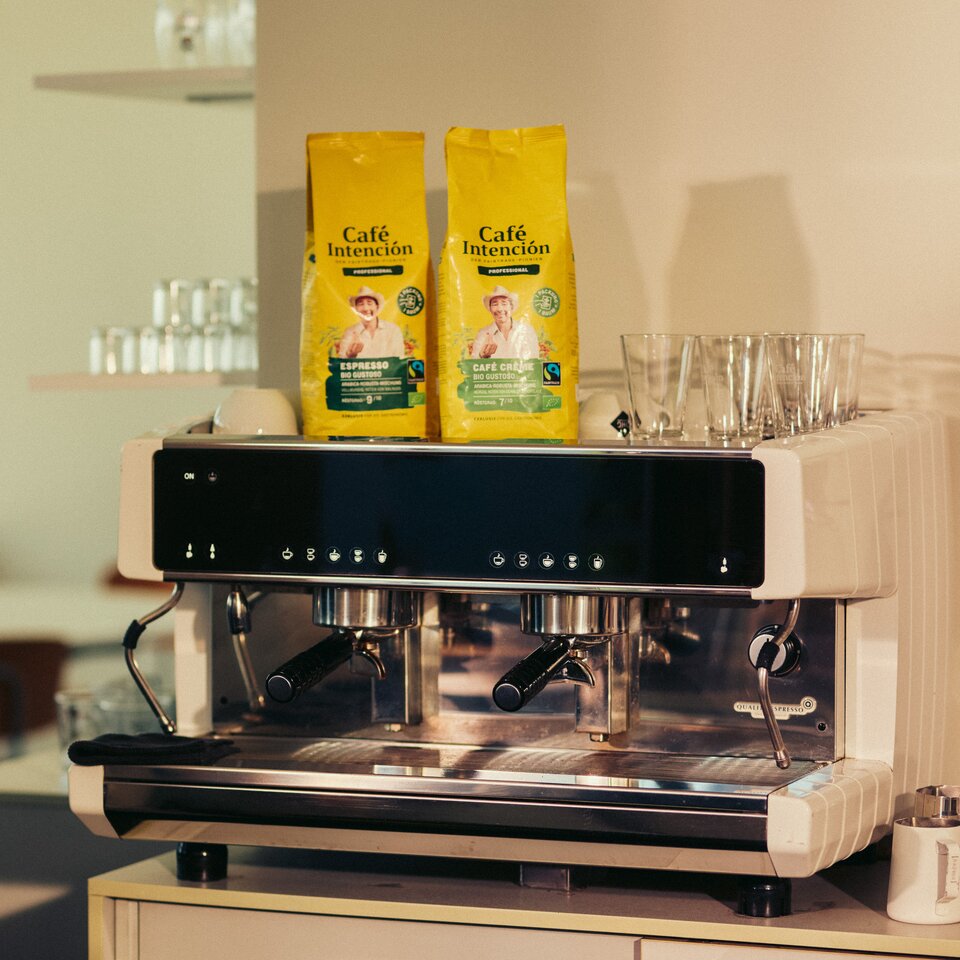 Espressomachine met Café Intención-koffiezakjes, die een moderne café-opstelling laat zien die perfect is voor koffieliefhebbers.